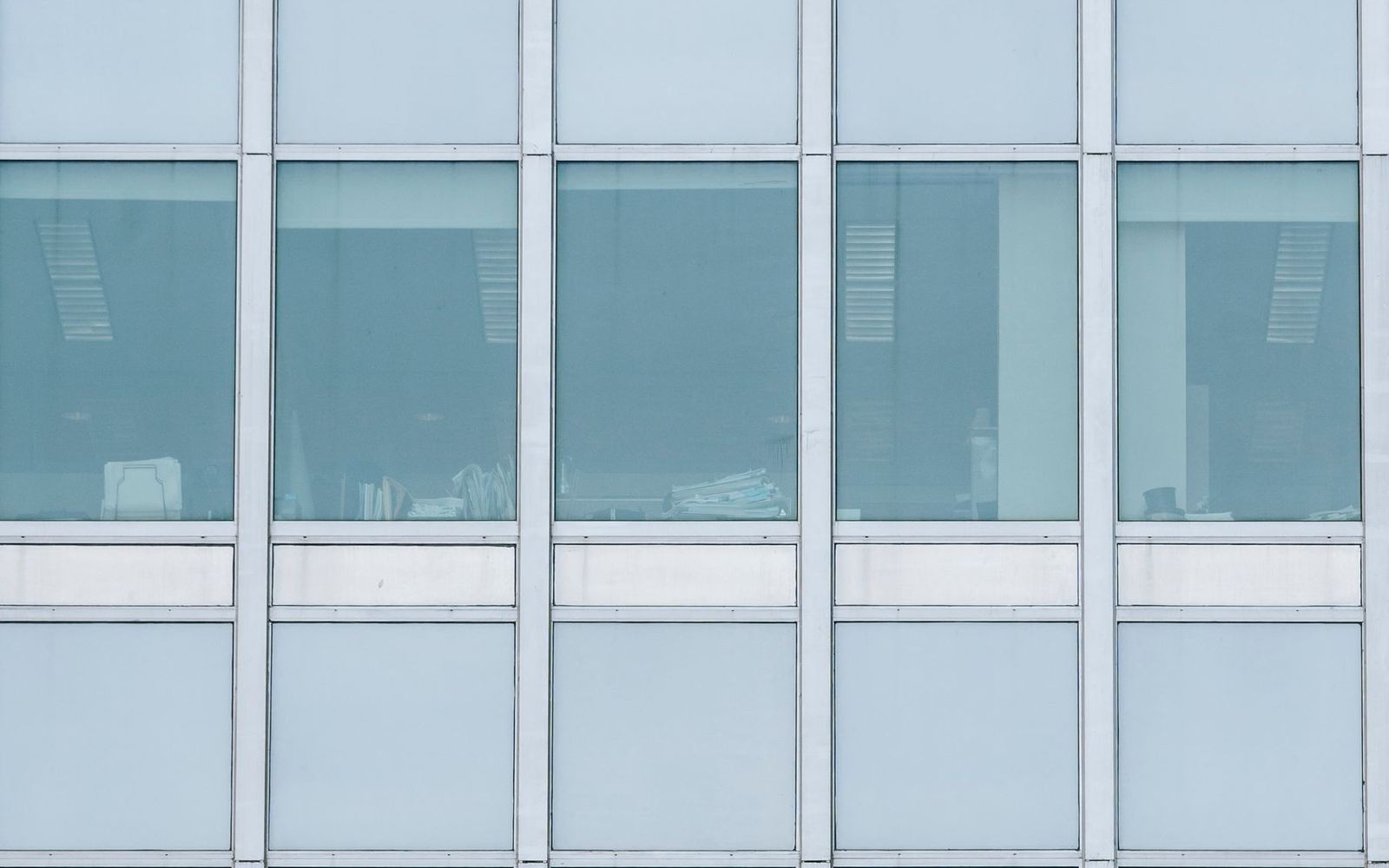The glass facade of a modern office building